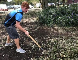 Sophomore DJ McCunney cleans up fallen tree branches in Orange County Academy. Along with three other friends, McCunney decided to help out the community after seeing all the damage caused by Irma. 