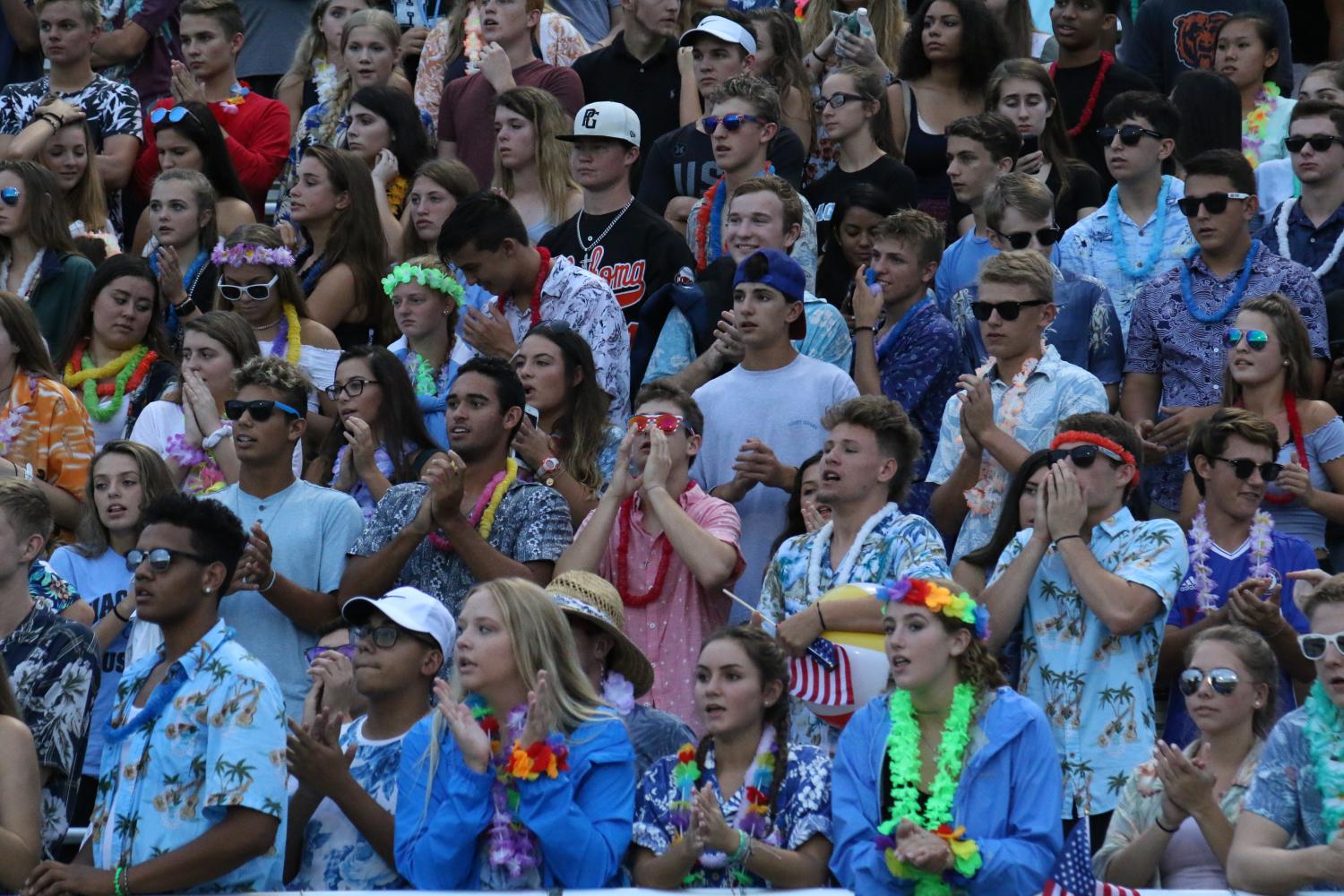 The student section displays abundant school spirit during a football game. Many school spirit events are in some way tied to football.