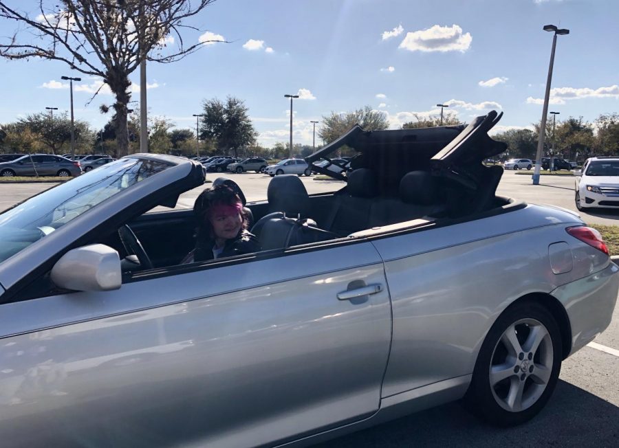 Junior Celeste Dixon takes down the roof of her convertible.  She drove it to and from school every day.