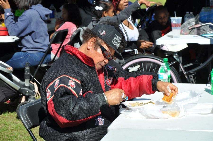 The community gathers to celebrate by eating barbecue, smoked on site at Round Lake Park. 