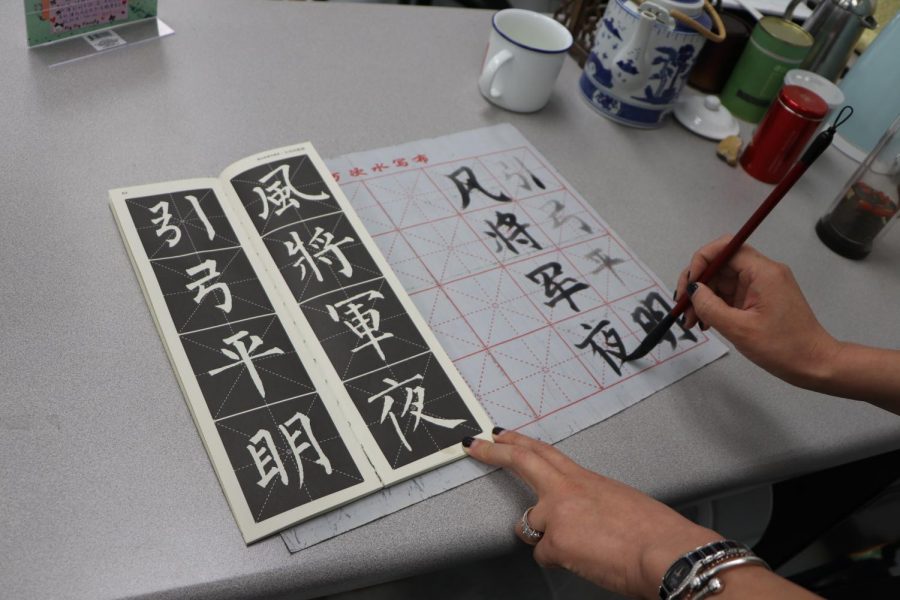 Chinese+teacher+Zhenzhen+Zhang+writes+characters+in+Mandarin+using+her+Mandarin+kit.