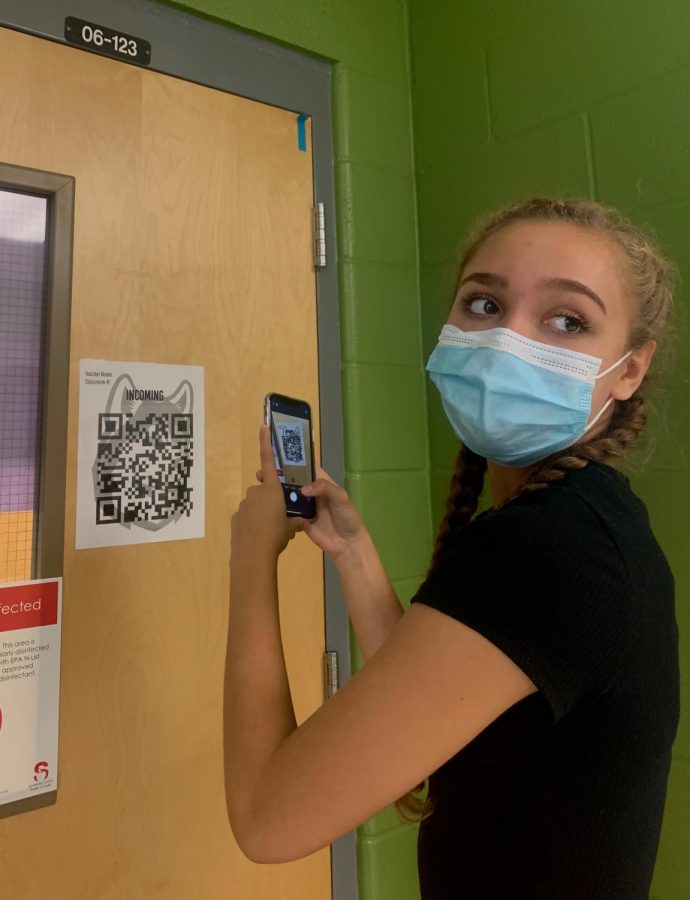Sophomore Leylani Neris scans back into her classroom so administration can track where she has been and what she has touched.  