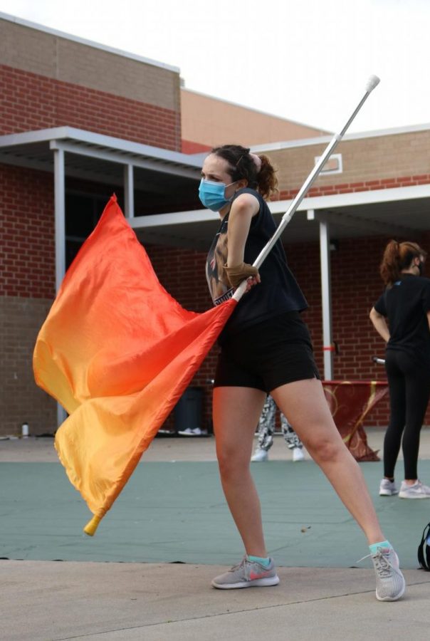 One of the few seniors on the team, Hannah Sanchez leads the winter guard during the flag routine, practiced immediately after the team ran around the courtyard.