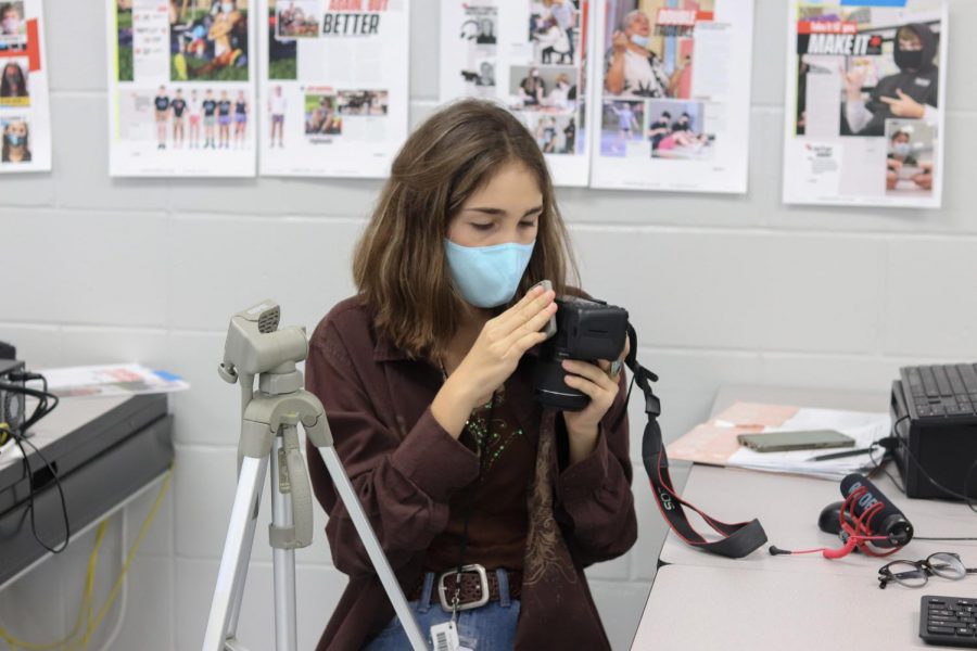 Sophomore Sophia Canabal constructs a tripod for her next video review for hhsblueprint.com.