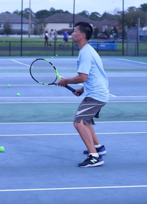 Senior Nicolas Cai prepares with the rest of his team for a match. In his doubles matches he was 7-4 and singles he was 4-7.