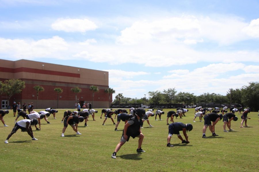 The varsity football team is stretching before their practice. 