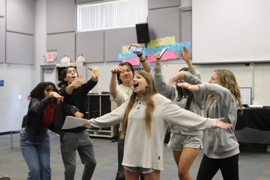 Junior Desiree Snell, sophomore Carter Wegmann, senior Courtney St. John, junior Alexane Ayup, senior Andy Ayup, and sophomore Julia Register rehearse their song and dance in a small group. To see the growth over the years has been exponential, Solomon said.  You can see the love [the students] put into everything theyre doing. 