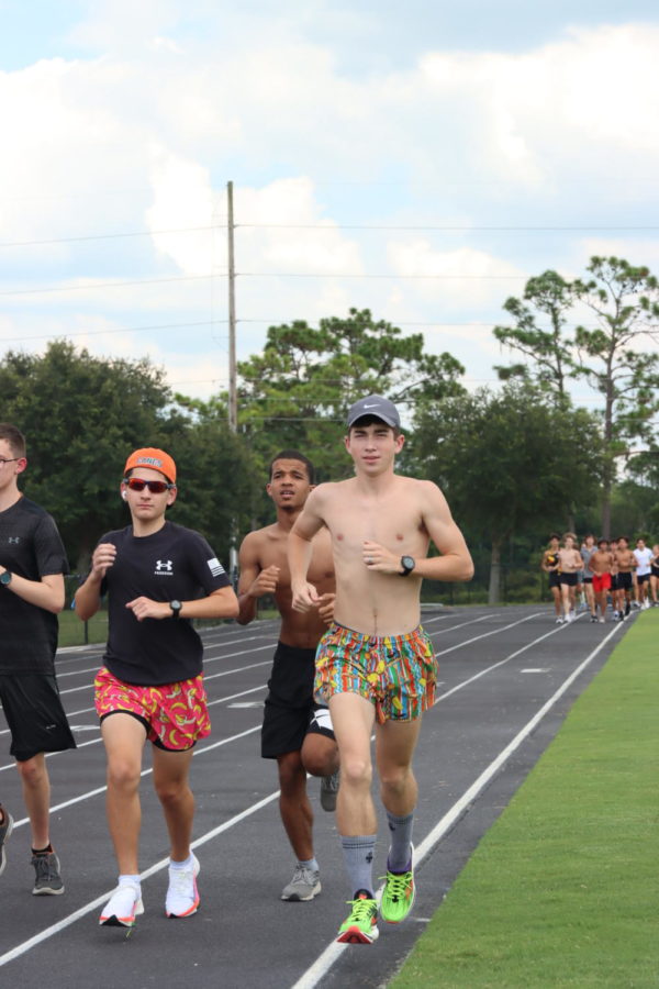 Seniors Owen Madsen and Marcus Watson, sophomore Nicholas Rodriguez, and junior Julian Scanlon run the backstretch of the track. The beginning of the backstretch of the track contains some craters in them which poses some dangers.