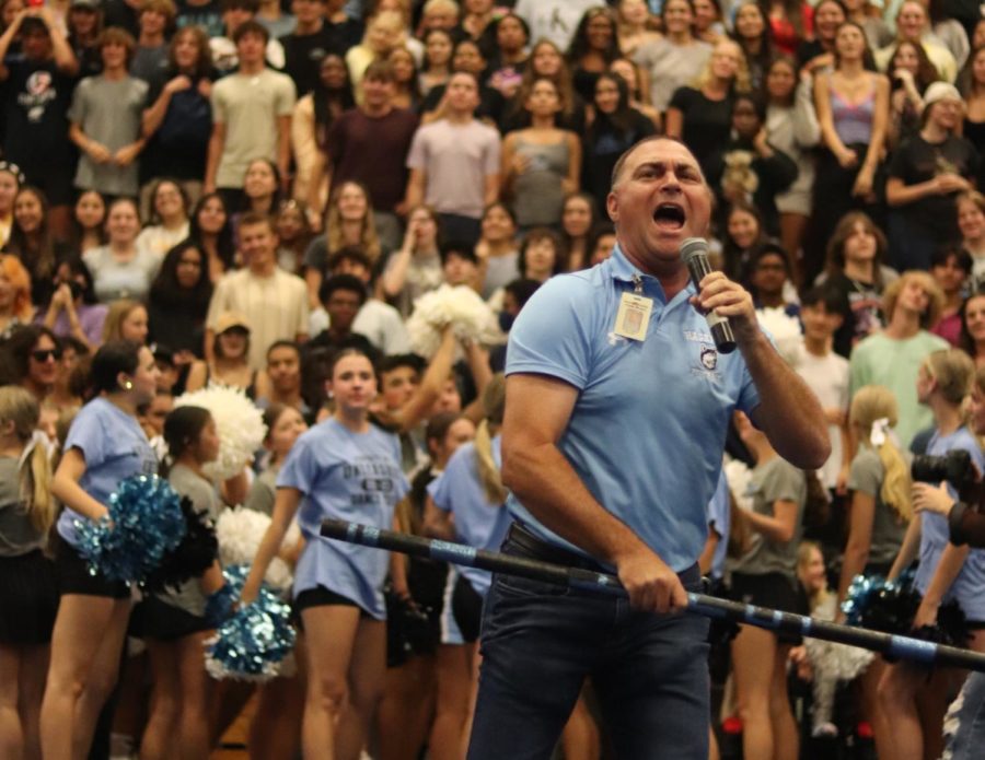 Principal Robert Frasca waves the spirit stick in the air. Pointing to each grade level, each grade cheered as loud as they could to win the spirit stick.