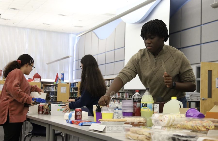BSU cabinet member MJ Pierre organizes food for the Thanksgiving potluck. Members from both groups were encouraged to bring food and drinks to share for the potluck. 