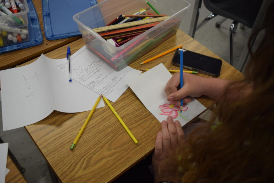 Poet Society member Ivy Thompson colors her flower drawing inside her card to send to sick children. Poet Society is free and encourages new members to join. 