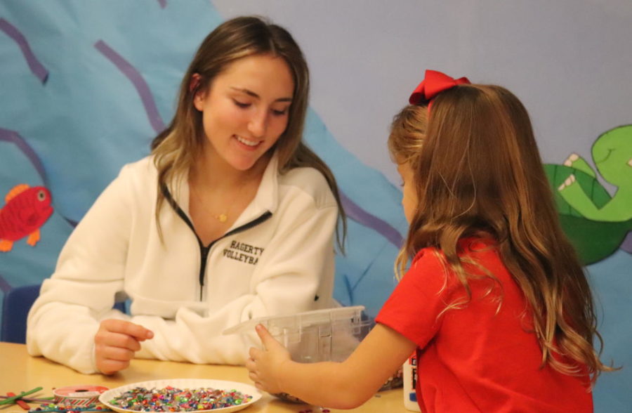  Freshman Ally Leech helps a child create a popsicle stick snowflake. FEA members had to split into groups and come up with holiday themed activities for the children to do.