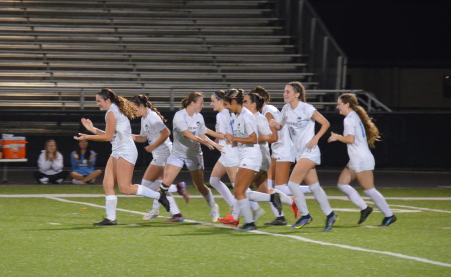 The+girls+varsity+soccer+team+celebrates+after+making+their+first+goal+against+Oviedo.+The+team+won+2-0.