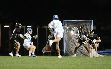 Conner McLaughlin scores a goal during the second half against Bishop Moore. The boys varsity lacrosse scored six unanswered goals in the second half but lost 9-8.