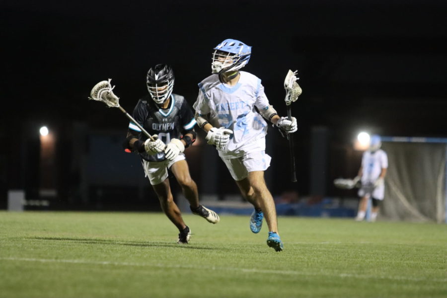 Attacker+Landon+Mclaughlin+runs+the+ball+up+the+field+on+the+way+to+scoring+his+second+goal.+The+boys+varsity+lacrosse+team+won+15-5+against+Olympia.