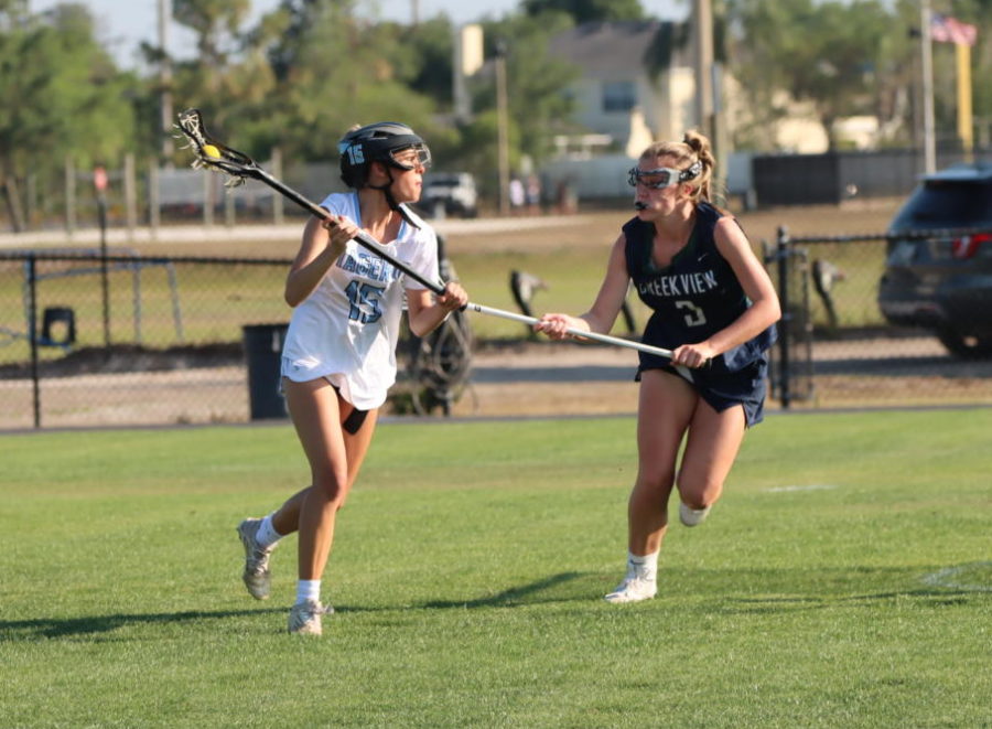 Attacker+Ella+Digore+dodges+her+defender+and+makes+an+assist+to+attacker+Ellie+Wilkins+for+the+first+goal+of+the+game.+The+girls+varsity+lacrosse+team+won+against+Creekview+9-7.