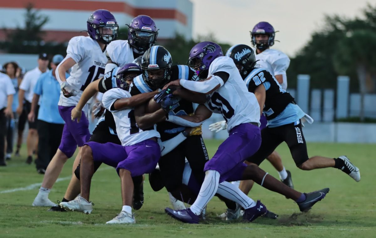 Running back Jalon Lewis fights his way through multiple defenders. Lewis averages 83.4 yards per game.