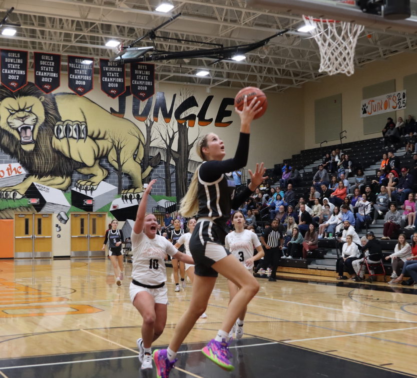 Forward Kylee Kitts goes for an open layup on a fast break. Oviedo players trail behind her.