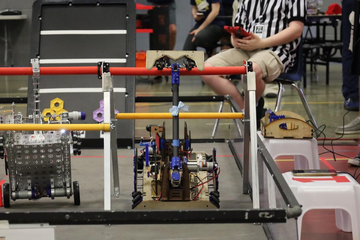 “Air Vent” successfully hangs on a PVC pipe, earning extra points for its alliance. Before building, robotics members modeled the machines using computer aided design and paper-pencil sketches, going through multiple prototypes before settling on a final design. 