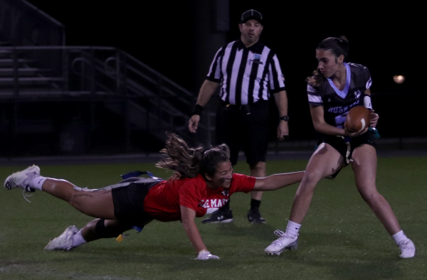 Senior Mina Stevens makes a run with the ball as the referee looks on. The play was intercepted by Lake Marys defense. 