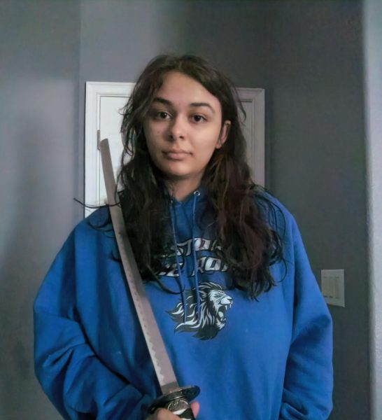 Senior Ashley Gorczany poses with her brides sword from Kill Bill. Although weapon collecting has recently become a hobby of Gorzany, she has enjoyed her experience learning about the weapons use and background.