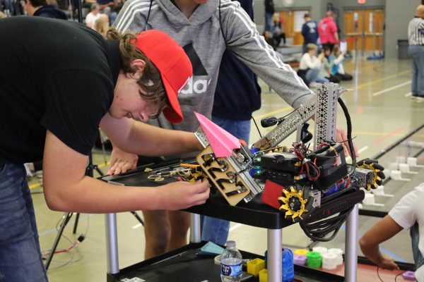 Junior Callan O’Connor makes last minute adjustments to team 4772’s robot before their qualifying match. Teams had been working on their robots since the beginning of the school year, and the league championships were the place to showcase their skills.