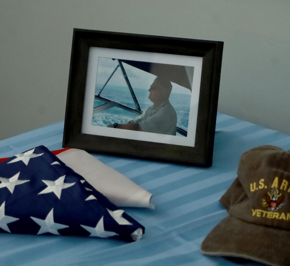 Haibels+military+service+flag%2C+U.S.+Verteran+hat+and+a+photo+of+him+on+a+boat+sit+on+the+welcome+table+for+his+Celebration+of+Life+service.+Haibels+memories+with+his+family+and+friends+were+shared+at+the+event+through+photos+and+storytelling.
