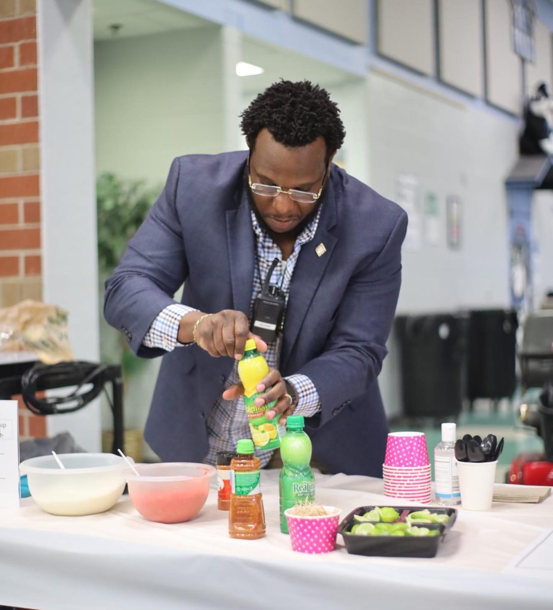 Assistant principal Reggie Miller preps components of his Mexican corn dish for staff to taste. This was the second annual Black History Month chili/sidedish cookoff.