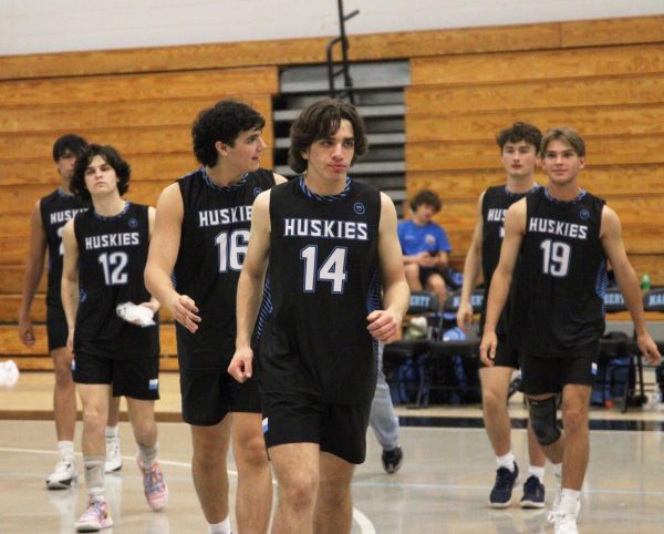 Senior Jackson Graeber leads the team onto the court after winning the first game. The boys ended the match with a loss, but they were proud of holding their ground. “We will keep our morale high because this caused a huge change in our mindset,” senior Marcel Clemens said.