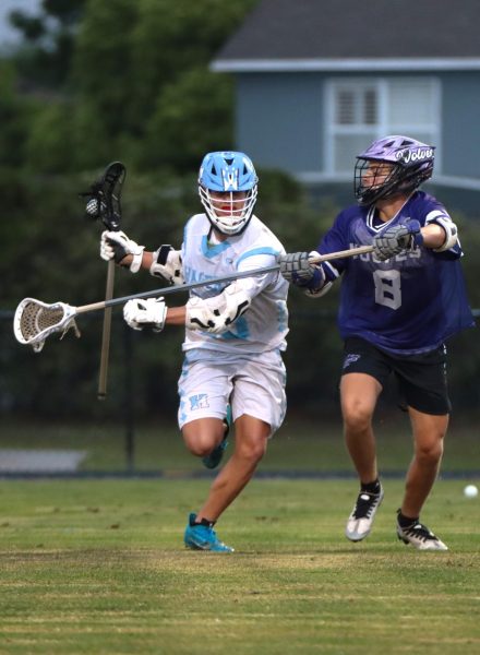 Attacker Parker Mediavilla protects his stick against a defender. The boys varsity lacrosse team lost to Timber Creek 12-3.