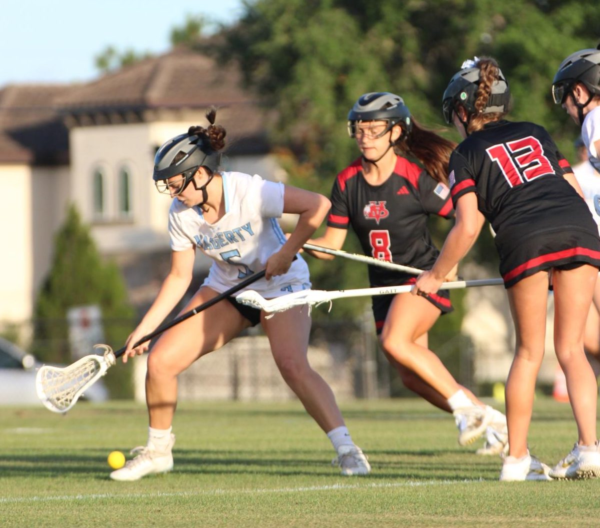Attacker Haley Thomas tries to grab the ball from the ground.  The girls lacrosse team lost to Vero Beach 6-5 on Friday, May 3.