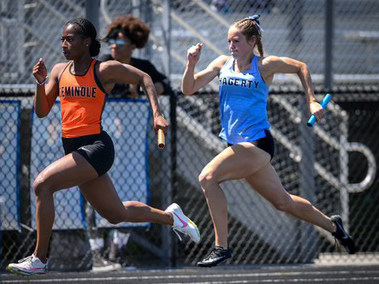 A Hagerty and Seminole runner sprint with baton in hand while compete in the 4x800 relay race.