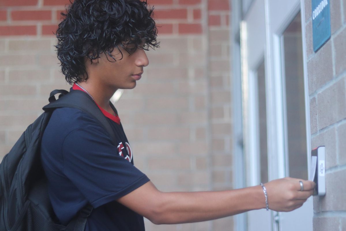 Junior Raul Davila scans his ID to get into his class's hallway in the morning. The new keypad/ID system is part of the recently-passed HB1473 bill.