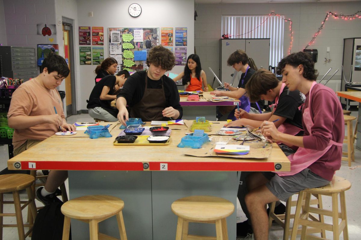 Students work on a painting project in 2D Art. Brushes and paper are supplied to students by teacherBeverly Sanchez.