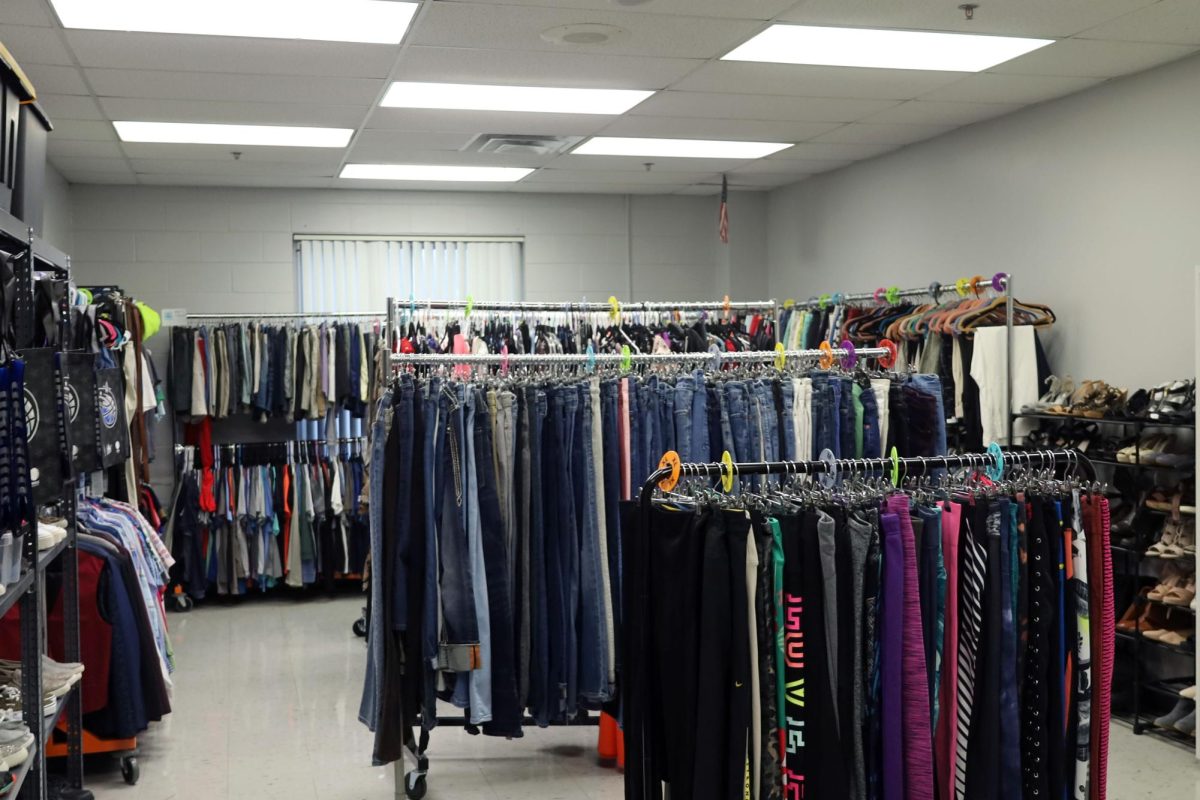 Sponsor Erin Isaacs, with support from volunteers and special education students, set up Avalanche's Attic for its community night event. Racks of clothing, shelves of shoes and baskets with hygiene products planned to be displayed for the community.