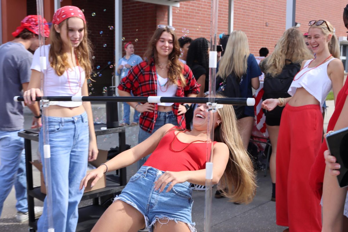 Senior Izabella Robinson participates in a limbo competition at the Monday Club Carnival. Leadership hosted the first-year event, and 16 clubs had booths set up at both lunches.