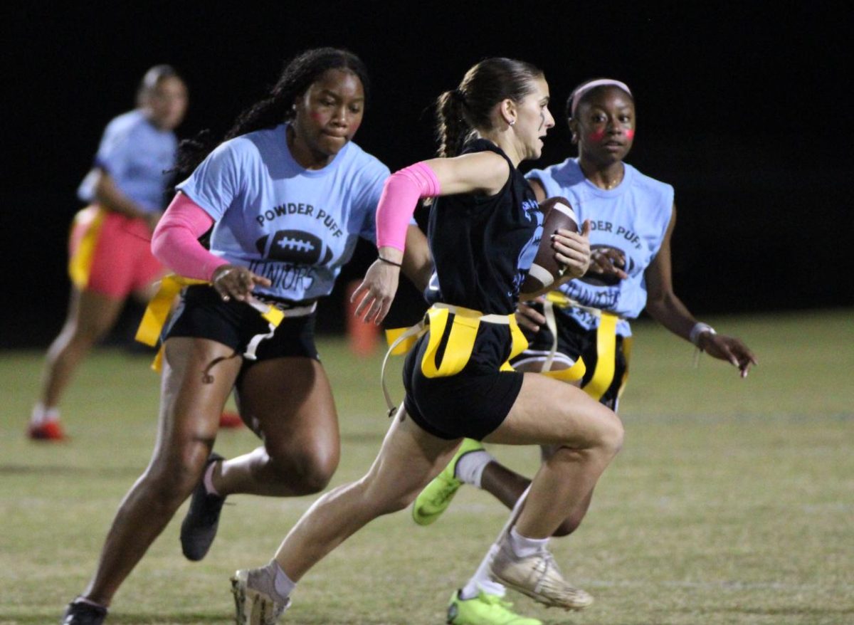 Juniors Suriyah Ali and Victoria Jones run after senior Gia Digiore in an attempt to make a tackle. Digiore was one of the top players for the senior team.