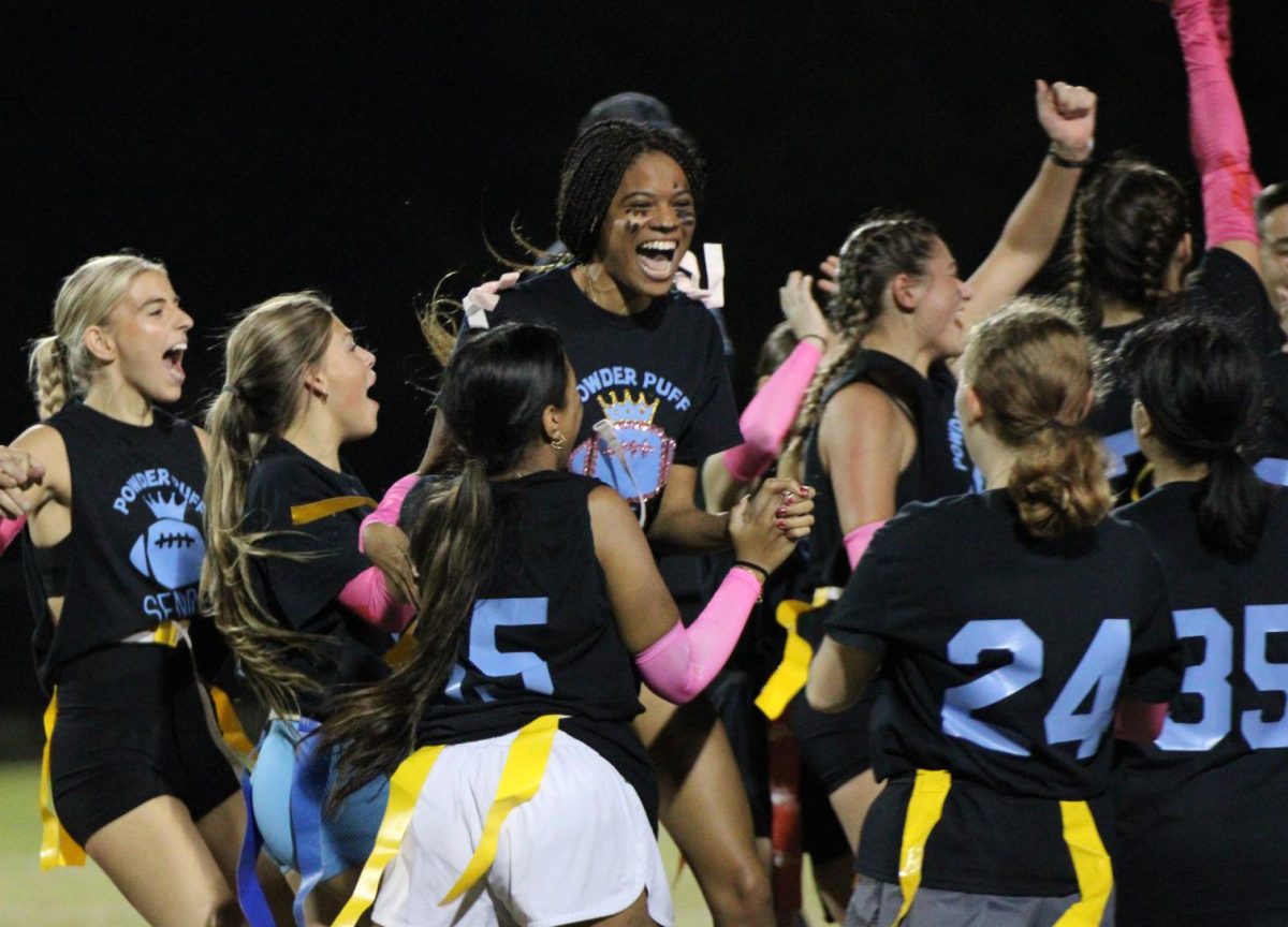 Natalie Cazeau and the senior powderpuff football team celebrate their victory. The seniors won 30-0 over the juniors.