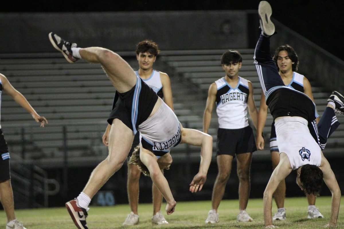 Senior cheerleaders Paul McKenzie and Otto Phanstid perform cartwheels during the powderpuff halftime show. Seventeen seniors were part of the cheer team.