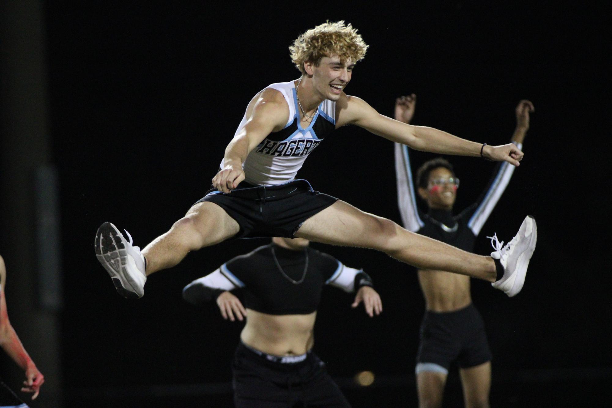 Junior Powderpuff cheerleader Drake Adkins performs a toe touch. Both junior and senior cheer teams performed at halftime.