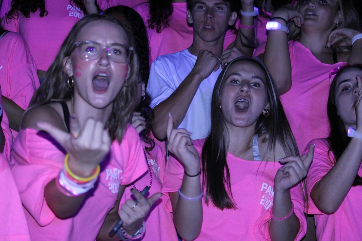 Senior Abigail Baeli and Haley Thomas cheer during Thursday's glow rally. Seniors wore pink for the event.