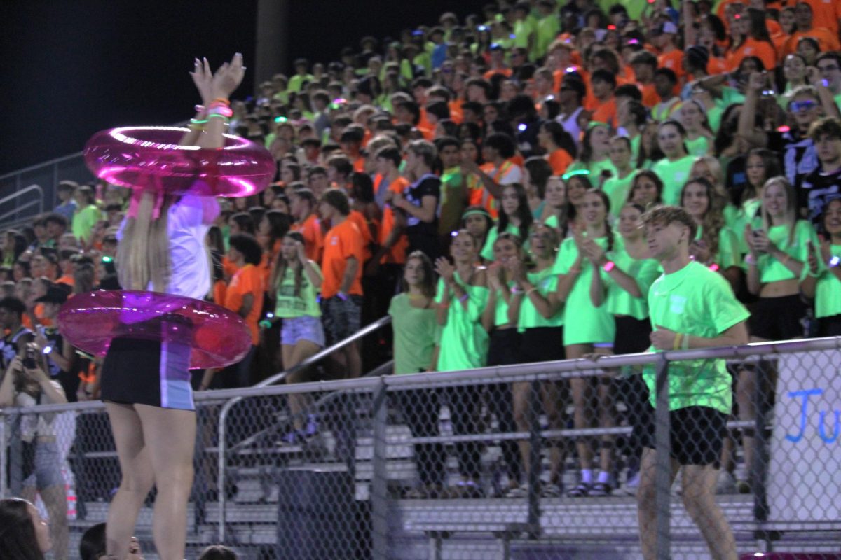 Junior Mitchell Richmond catches plastic inner tubes to give to the crowd during the pep rally. Richmond, along with the rest of the Leadership class, ran all the events of homecoming week.