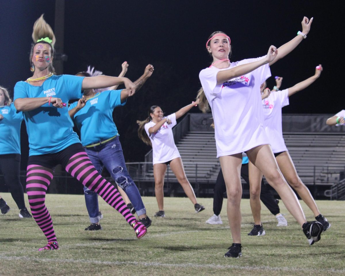 Counselor Andrea Fuhrer and senior Addison Brinker dance to "Soulja Boy" at the beginning of the event. Teachers and dance team members paired up to perform.