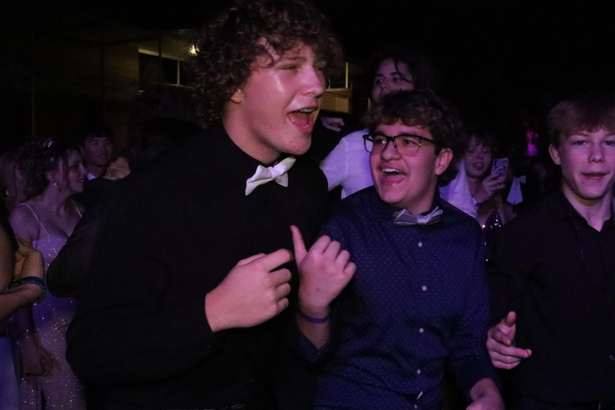 Sophomore Bryson Taylor sings and dances with friends during the homecoming dance. The dance took place in the school courtyard.