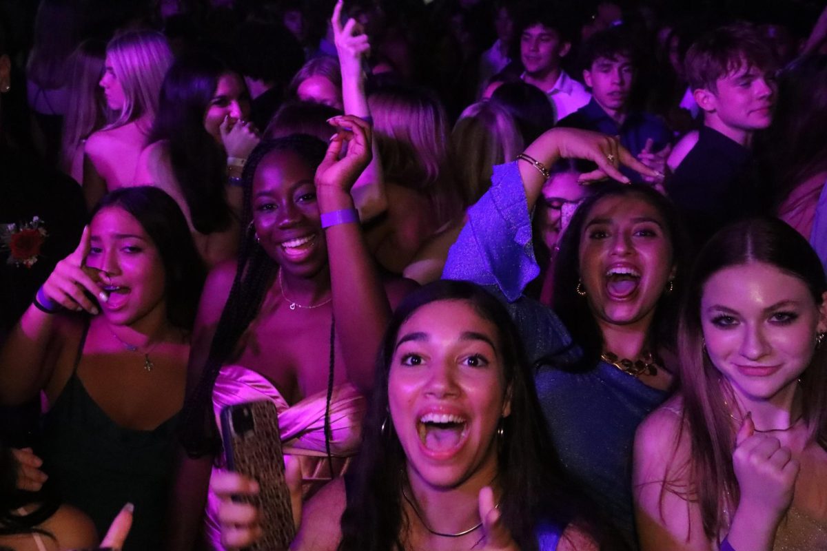 Freshman Mya Hall, senior Meghna Vikram and junior Isabella Semmel dance with friends during the homecoming dance. The dance marked the final event of homecoming week.