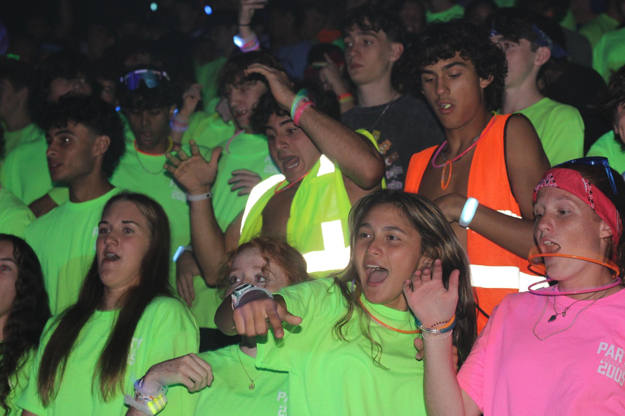 Juniors Lucas McFarland, Mohamad Mutawe, Zoe Nowaak and senior Jenna Bower dance to the music at Thursday's glow rally. The nighttime pep rally had become a five-year tradition.