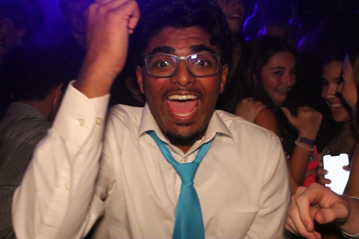 Senior Jason Joseph sings in the mosh pit during the homecoming dance. The DJ played a mix of pop music and rap.