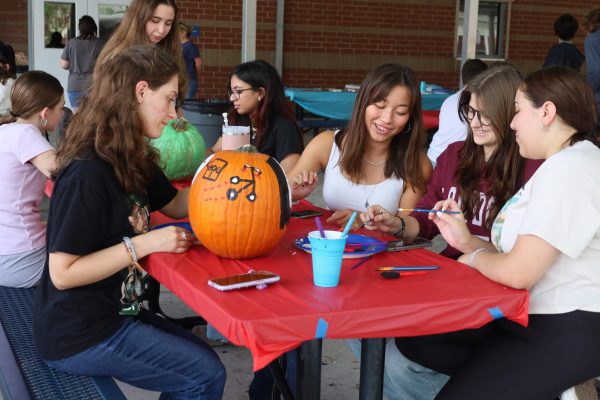 Junior Michelle Henry paints a pumpkin with friends. Student Ambassadors' annual Pumpkin Painting Palooza attracts a variety of students, both members and non-members.