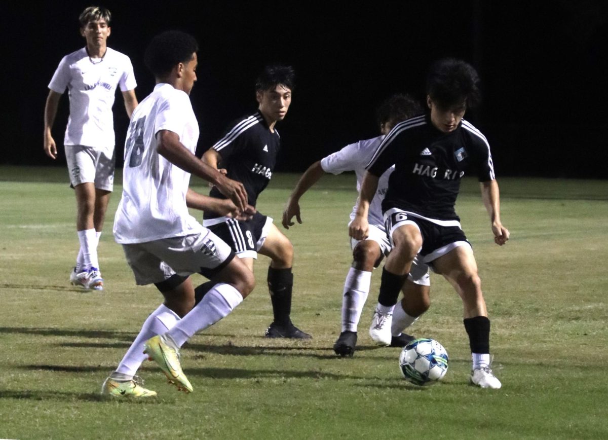 Senior Adrian Davilla passes the ball behind him to senior Daniel Erazo. Both Erazo and Davilla serve as forwards on the team.