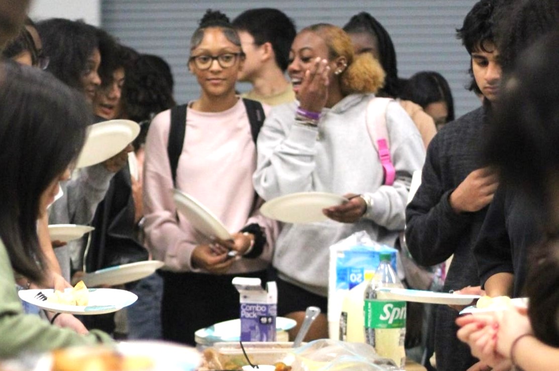 Students select food arranged on the cafeteria table. The clubs organized their different foods and students stood with their plates in a line moving to grab the food they please.  Photo by Shalyni Patel